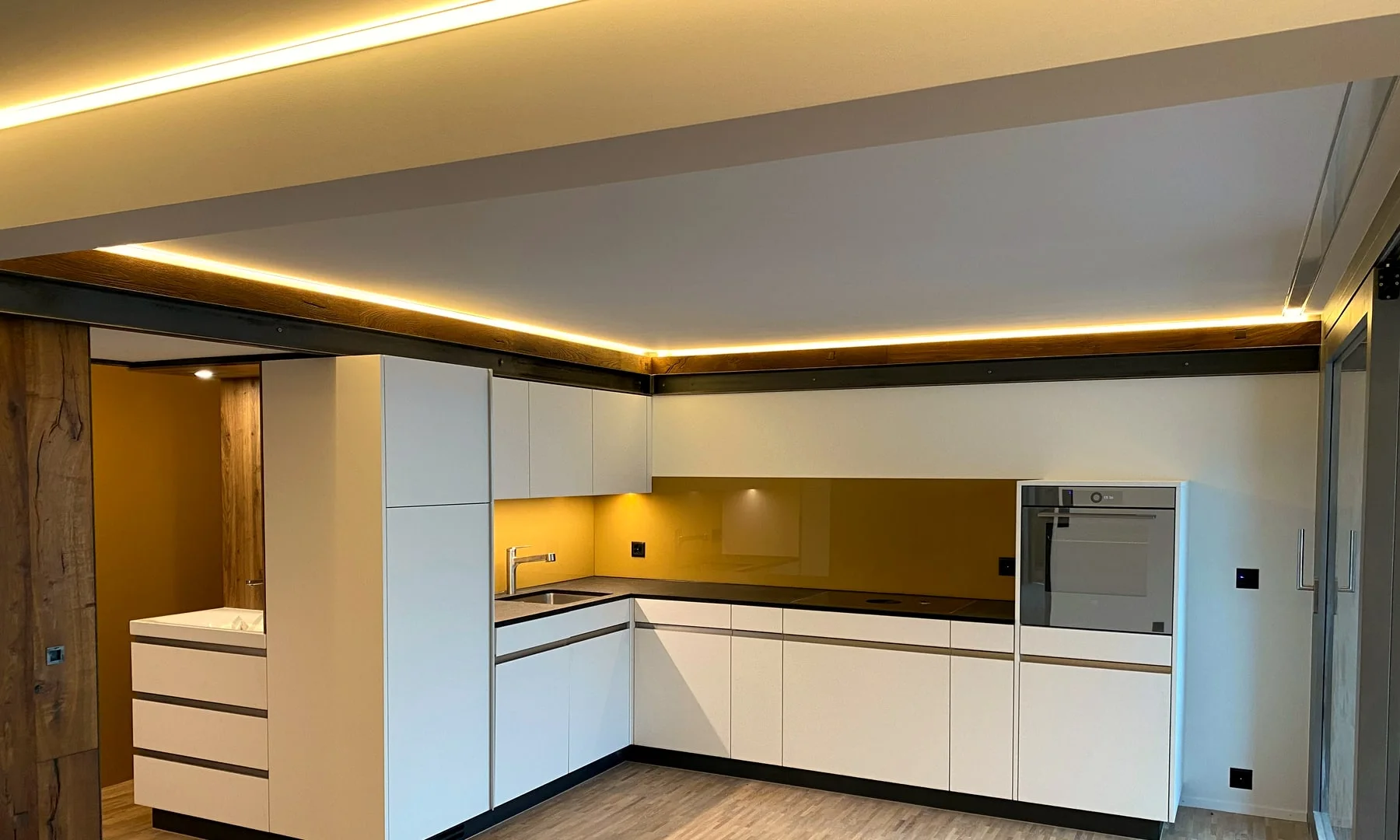 Moderne massgefertigte Wohnküche mit Holzboden und Kochinsel