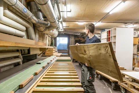 Mitarbeiter bei der präzisen Bearbeitung von Holzteilen
