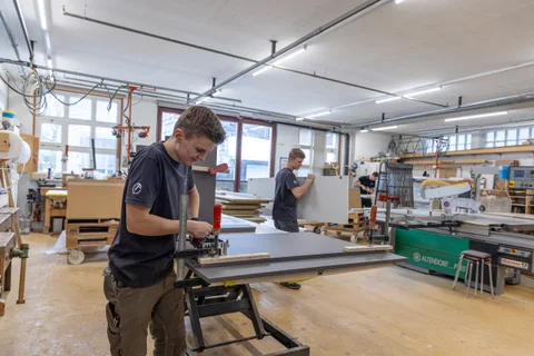 Teammitglieder bei der Arbeit an der Hobelbank in der Werkstatt
